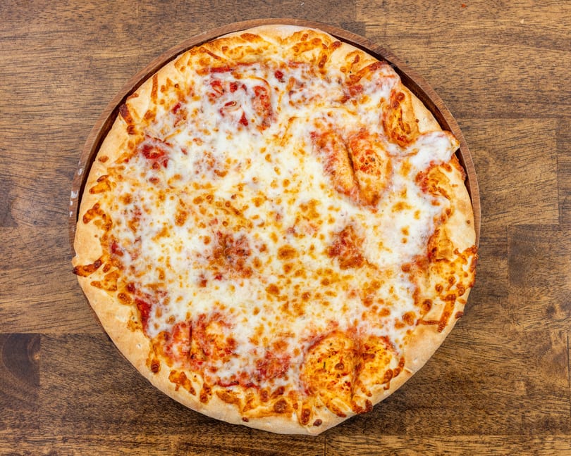 A whole cheese pizza with melted mozzarella and tomato sauce on a wooden serving board.